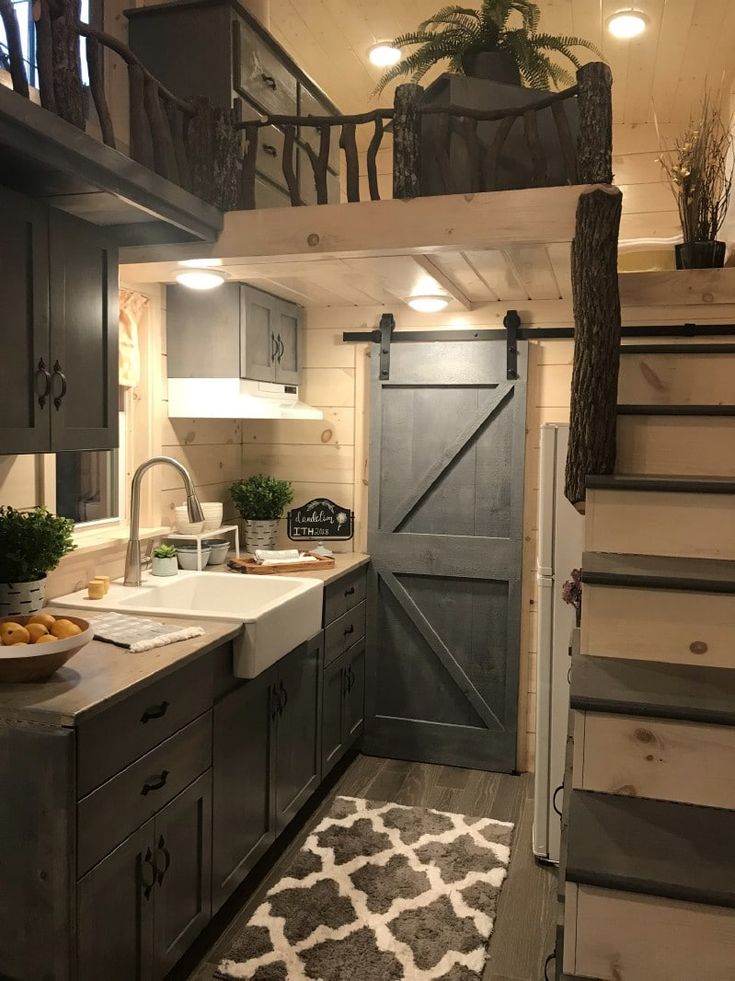 an instagramted photo of a tiny house with stairs leading up to the kitchen