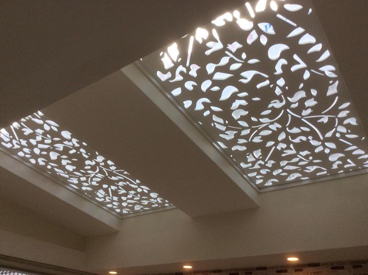 the ceiling is decorated with white flowers and leaves, while lights shine from above it