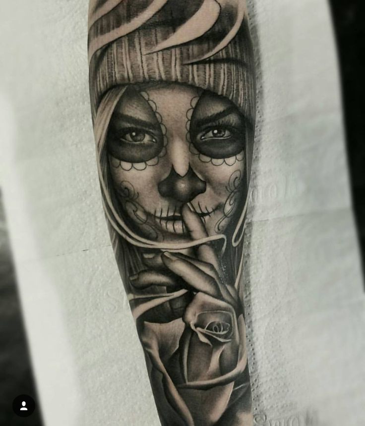 a woman's arm with a skull and rose tattoo on it