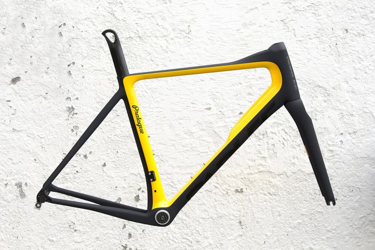 a yellow and black bike frame hanging on the wall