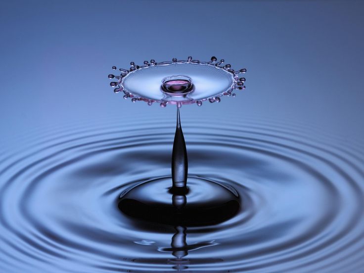 a drop of water is shown in the middle of it's reflection on the surface