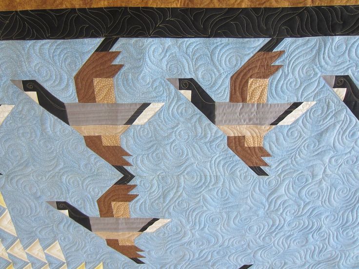 three geese flying in the air on a quilt