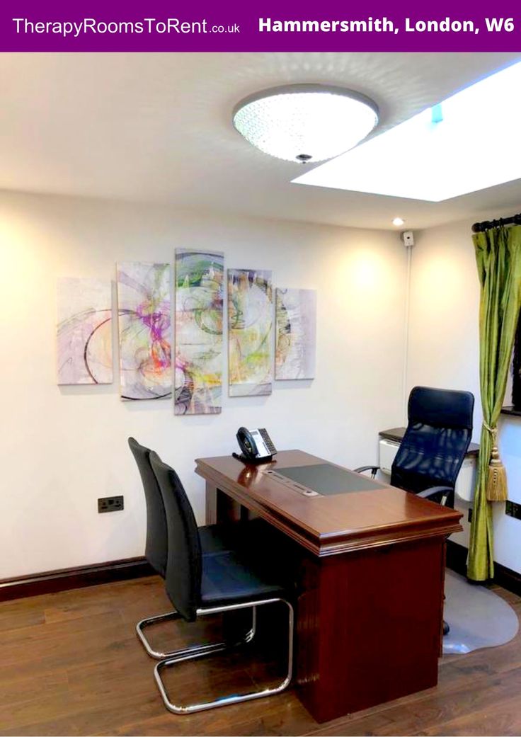 an office with chairs, desk and paintings on the wall