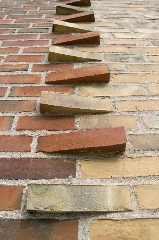 an image of a brick wall that is going up to the ground with bricks on it