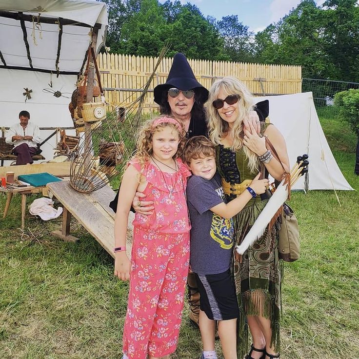 a family poses for a photo in front of an old - fashioned pirate ship tent