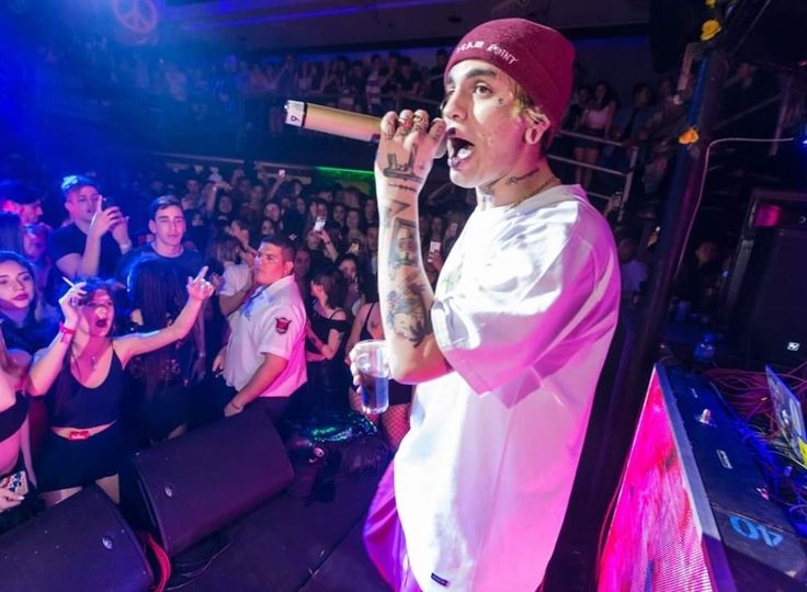 a man standing on top of a stage holding a microphone in front of a crowd