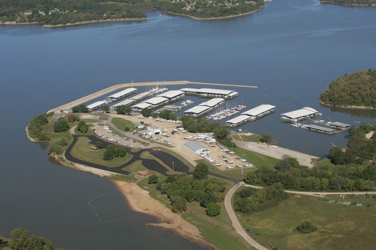 an aerial view of a marina with many boats in the water and trees around it