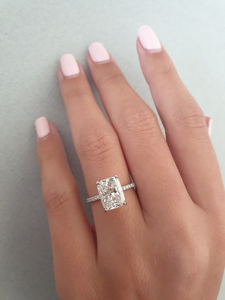 a woman's hand with a diamond ring on it