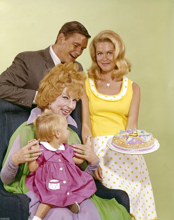 a man and two women sitting on a couch with a baby in front of them