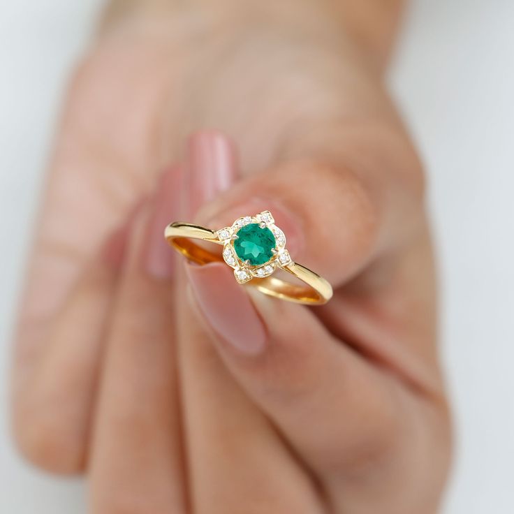 Product Details Revive your cherished moments with our elegant Vintage-Style Ring. This stunning piece showcases a Round Shape lab created emerald at its center, nestled in a claw setting. The ring is further enhanced by Diamond accents, giving it a refined and eye-catching appearance. Product Information SKU SHP-RINGS0821169255 Width 4.5 mm Height 9.2 mm Weight 1.70 gm (Approximate) LAB CREATED EMERALD INFORMATION No.of Stones 1 Pieces Total Weight 0.53 Carat (Approximate) Dimension(approx) Rou Emerald And Diamond Engagement Ring, Lab Created Emerald, Vintage Style Rings, Claw Setting, 18k Yellow Gold Ring, Emerald Gemstone, List Style, Gold Engagement Rings, Font Size