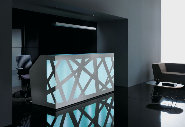 a black and white reception area with an illuminated counter in front of the room's door