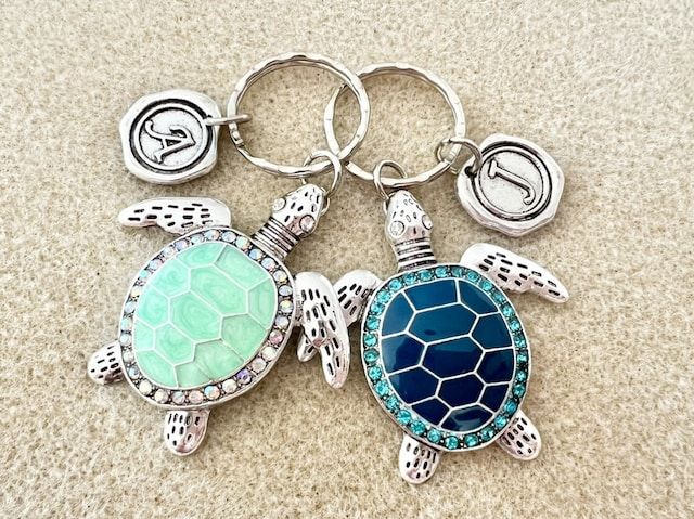 two sea turtle keychains are shown on the floor