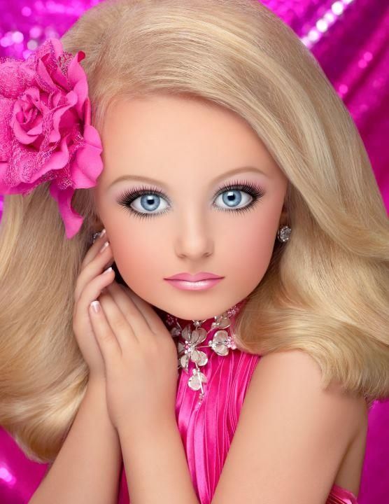 a barbie doll wearing a pink dress and flower in her hair