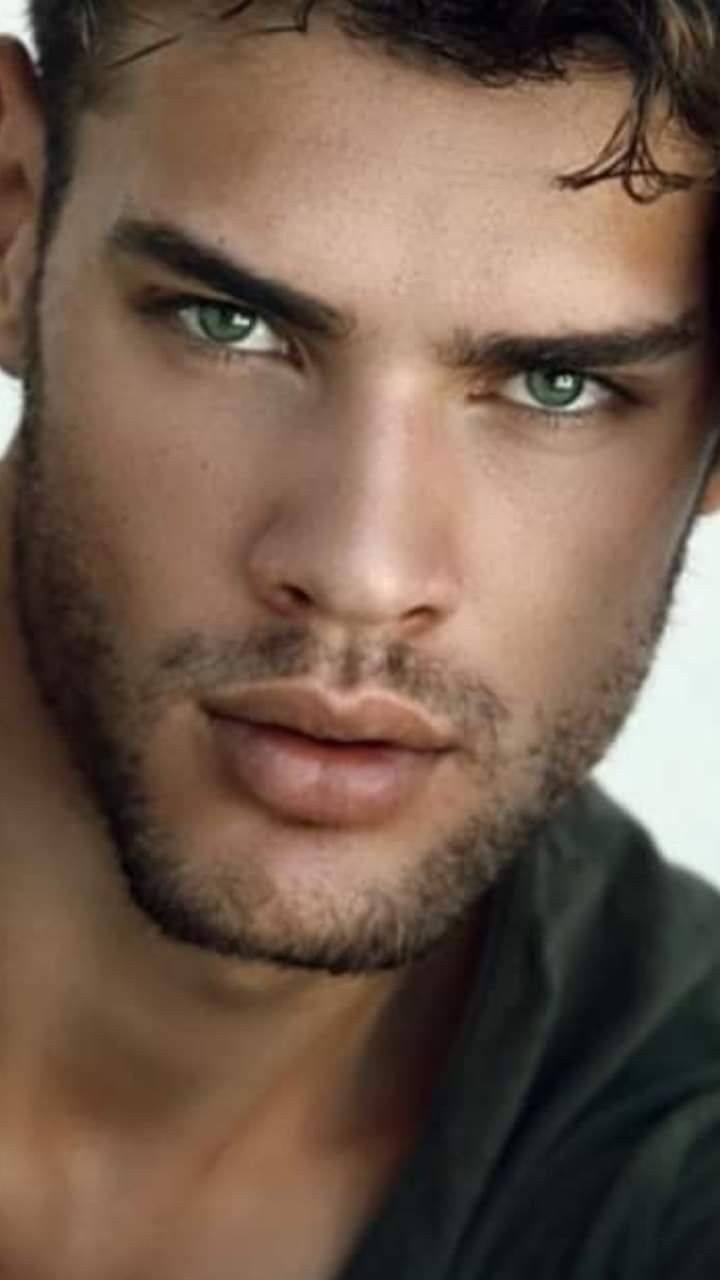 a close up of a man with green eyes