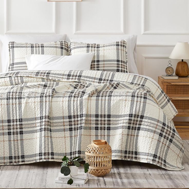 a bed with white and black plaid bedspread