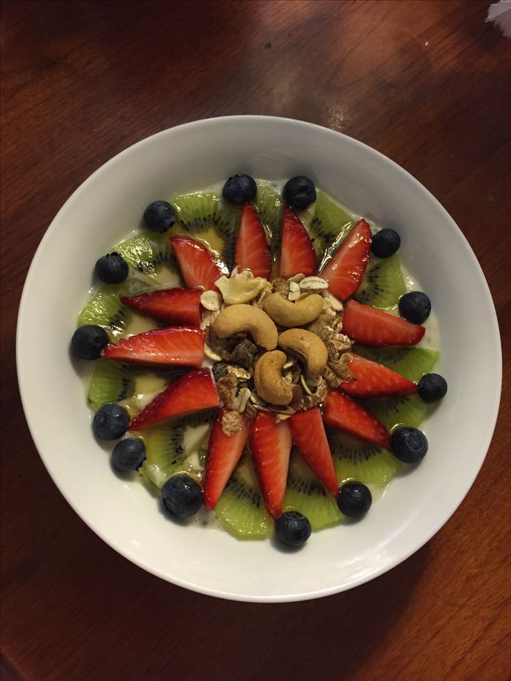 a white bowl filled with fruit and nuts