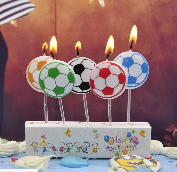 three soccer ball candles on top of a cake