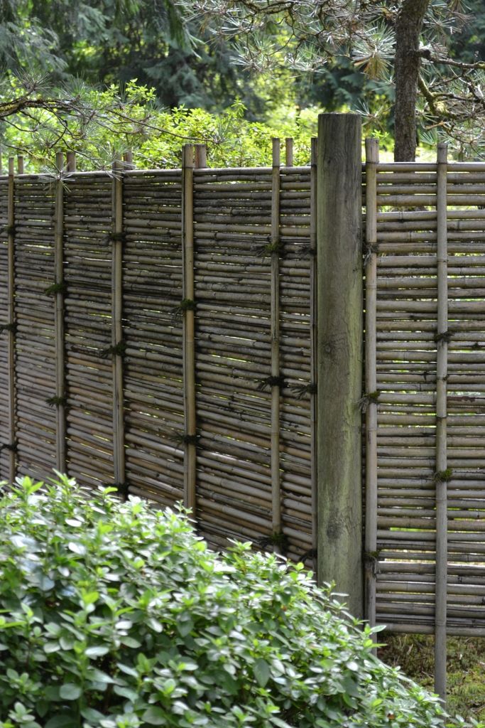 a wooden fence is surrounded by bushes and trees