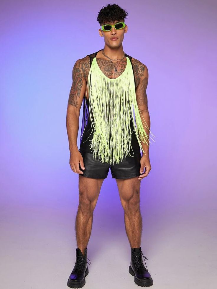 a man in black shorts and neon yellow fringe vest posing for the camera with his hands on his hips