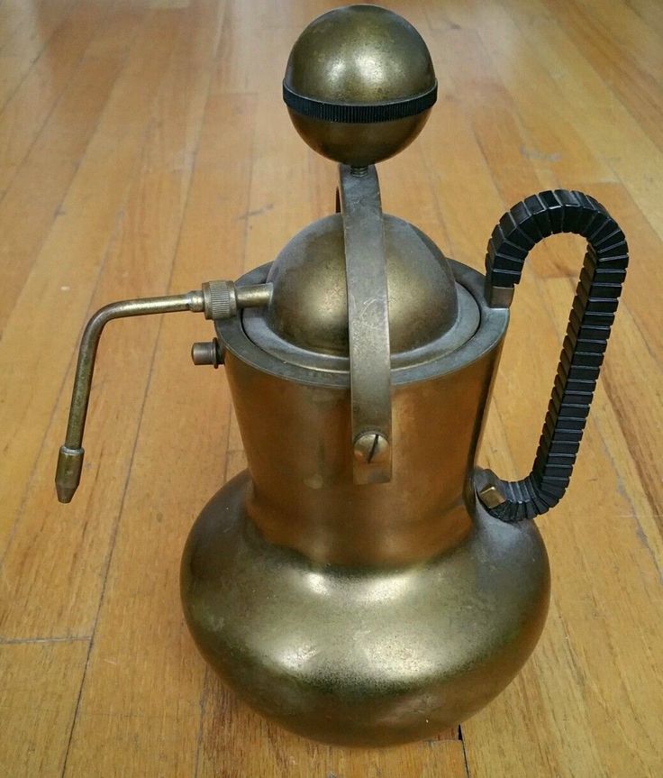 an old fashioned coffee pot on a wooden floor