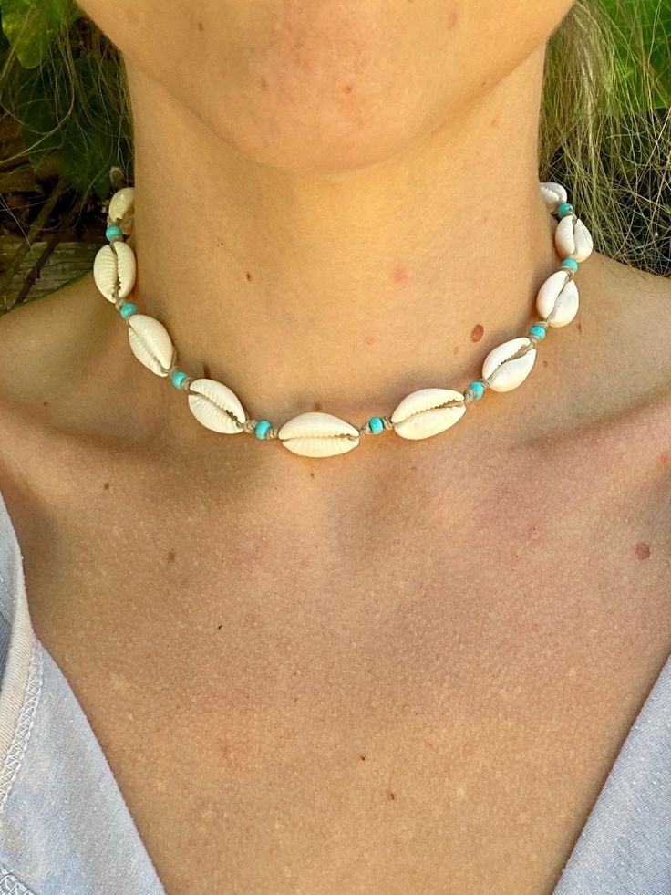 Hand made genuine cowrie shell choker necklace with aqua blue glass beads, knotted organic hemp and a coconut shell button. This necklace is metal free. It measures 16 inches from end to end. Please measure your neck or favorite necklace to make sure you get a good fit! If you are interested in a custom size, send me a message!  Each necklace is made to order and will ship 1-2 days from when you place your order.  These are also hand made with real natural shells and glass beads and may vary slightly from the picture due to Mother Nature making every shell unique :) Handmade Jewelry With Round Beads For Beach Season, Beaded Jewelry Gift For Beach Season, Turquoise Shell Necklace For Summer, Handmade Turquoise Jewelry For Beach Season, Turquoise Strand Jewelry For Festival, Handmade Blue Jewelry For Beach Season, Handmade Turquoise Beachy Jewelry, Turquoise Shell Necklace Summer Gift, Adjustable Cowrie Shell Jewelry For Beach Season