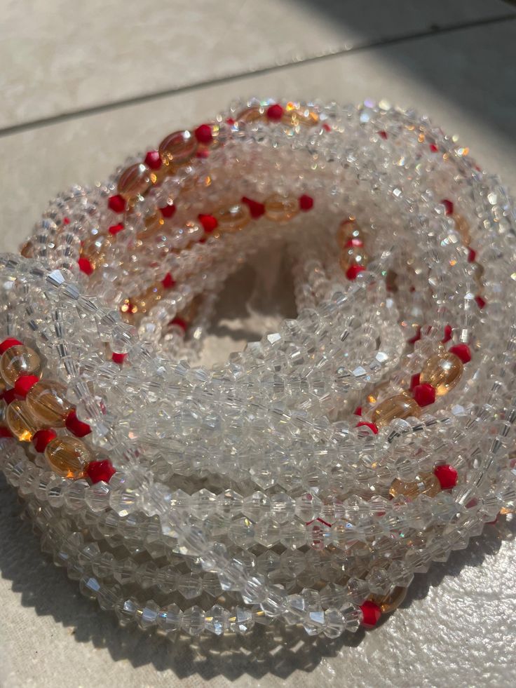 Elastic Waist Bead "Aboisso" crafted with luminous white glass crystal seed beads and adorned with subtle accents of passionate red crystal seed beads. This elastic waist bead not only epitomizes purity but also infuses a touch of fiery elegance, offering a comfortable and adjustable fit that transcends beauty and symbolism. 🌟 White Glass Crystal Seed Beads - Ethereal Radiance: Aboisso is adorned with a symphony of radiant white glass crystal seed beads, symbolizing purity and ethereal radiance Red Spiritual Crystal Bracelet With Round Beads, Adjustable White Waist Beads With Spacer Beads, White Spiritual Crystal Necklaces With Faceted Beads, White Spiritual Crystal Necklace With Faceted Beads, Gemstone Waist Beads As Gift, Gift Gemstone Waist Beads, Festive White Beaded Necklaces With Colorful Beads, White Faceted Beads Waist Beads For Gift, White Beaded Necklace With Faceted Beads For Festive Occasions