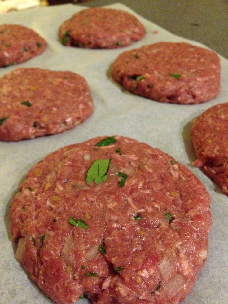 raw hamburger patties on a baking sheet ready to be baked