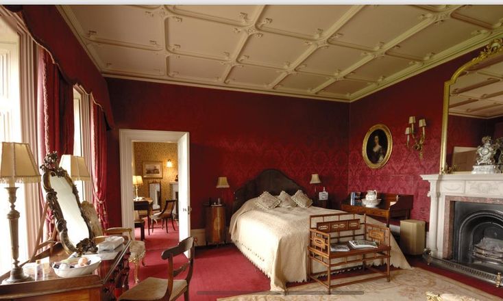 a bedroom with red walls and carpeted flooring