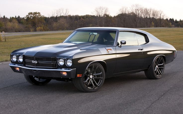 an old muscle car is parked on the road