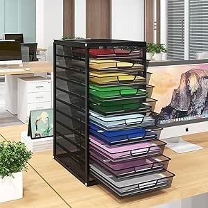 a computer desk with a stack of folders on it