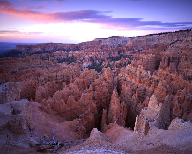 the sun is setting over an area that looks like it has many different formations and colors