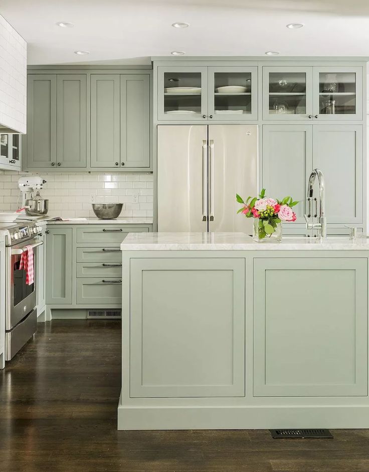 a kitchen with green cabinets and white counter tops