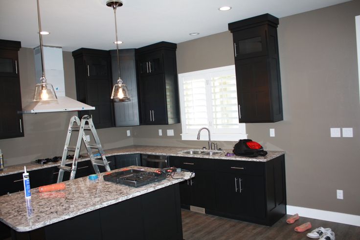 a kitchen with black cabinets and marble counter tops in the process of remodeling