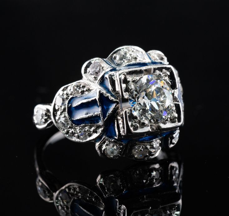 This vintage ring is crafted in solid 14K White Gold (carefully tested and guaranteed). The center Old European cut diamond is .75 carat of VS1 clarity and G color! It is accented with 18 mine cut diamonds of SI1-I1 clarity and H color totaling .38 carat. The blue enamel is in mint condition. The top of the ring measures 13mm top to bottom. The setting elevates 6mm high above finger. Size 4.5 (sizable). The ring weighs 4.2 grams. Great vintage condition. T5183455 Formal Round Enamel Diamond Ring, Art Deco Enamel Rings For Formal Occasions, Wedding Enamel Ring With Diamond Accents, Heirloom Style Enamel Rings For Anniversary, Heirloom Enamel Ring For Anniversary, Heirloom Enamel Rings For Anniversary, Art Deco Enamel Jewelry For Anniversary, Diamond Enamel Ring With Brilliant Cut For Anniversary, Diamond Enamel Ring With Diamond Accents For Anniversary