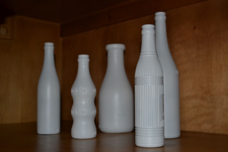 several white bottles lined up on a shelf