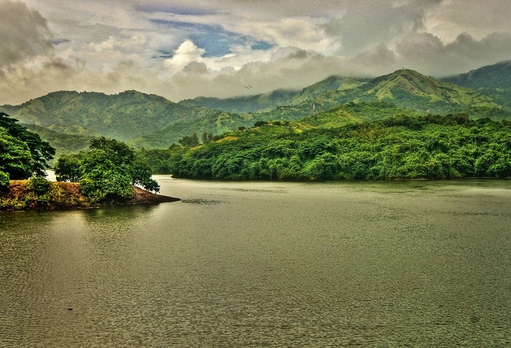 a body of water surrounded by lush green mountains