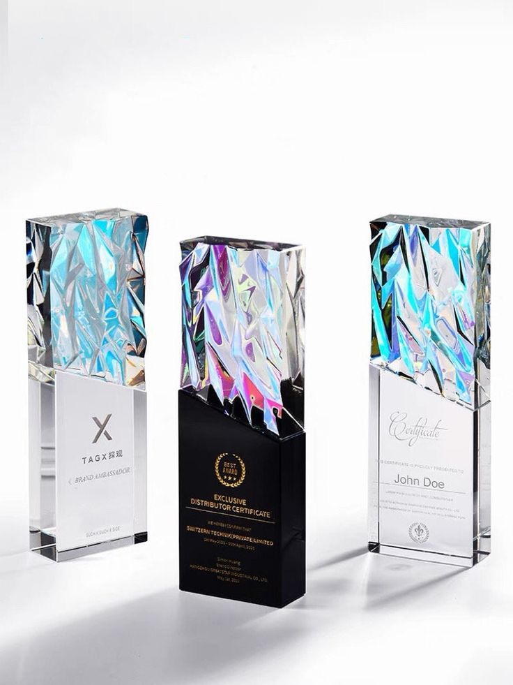 three award plaques with different designs and colors on them, one is black, the other is white