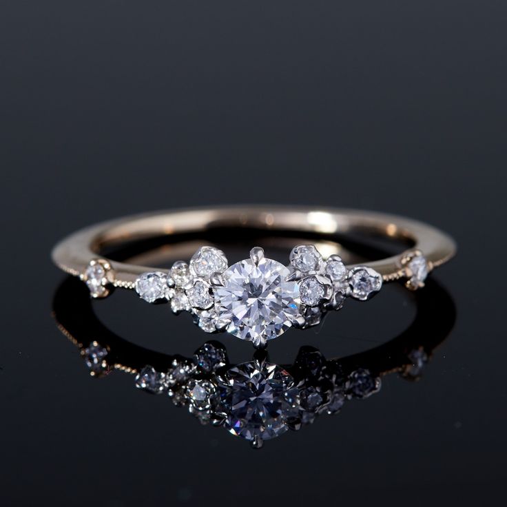 a three stone diamond ring on a black surface