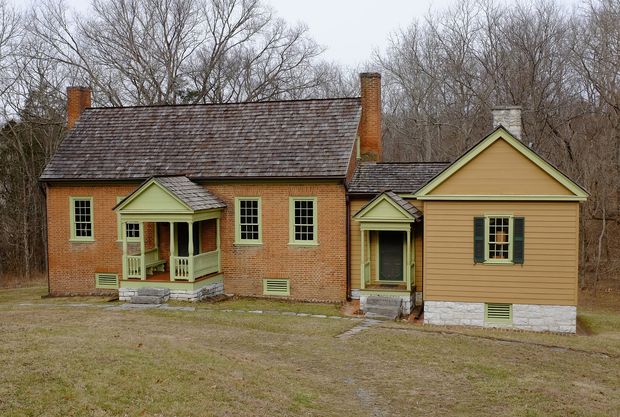 an old brick house in the middle of a field