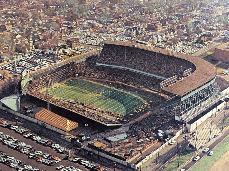 an aerial view of a football stadium with cars parked in the lot