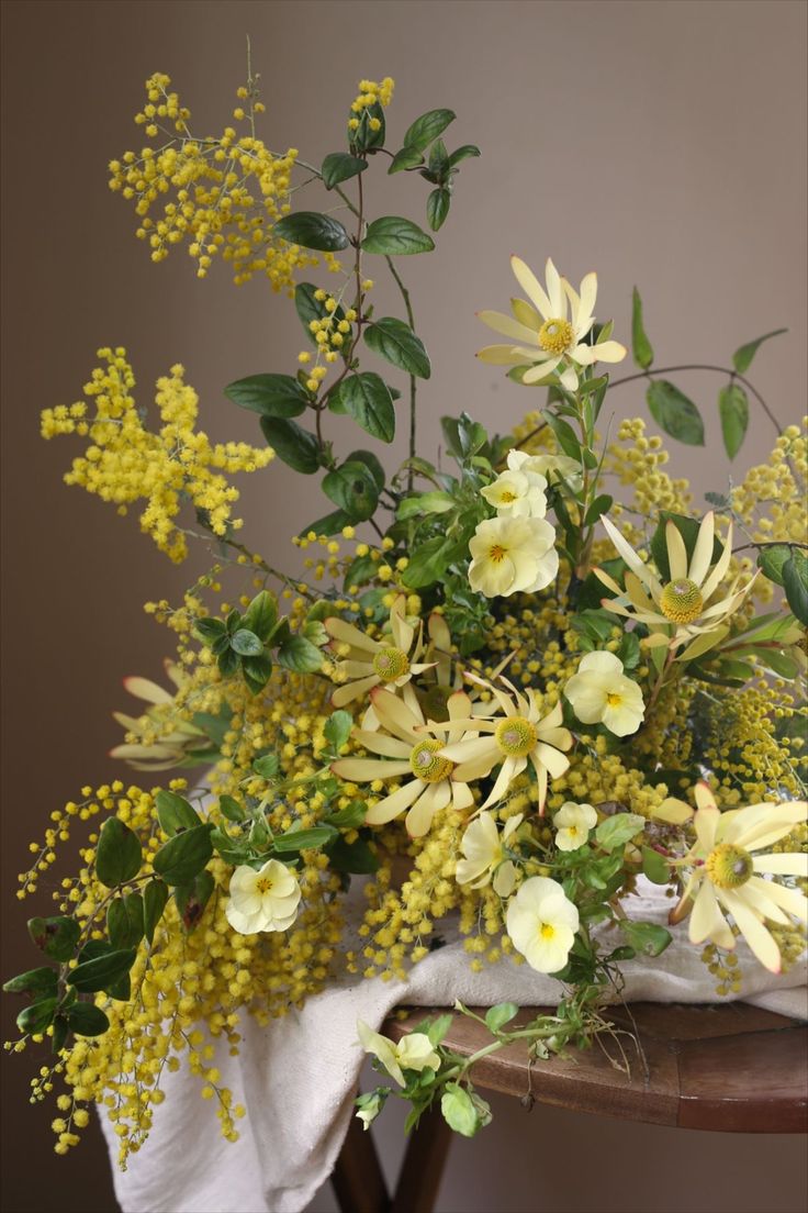 a bouquet of yellow flowers sitting on top of a table