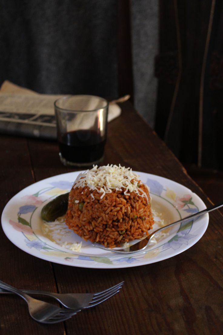 a white plate topped with rice covered in sauce and grated parmesan cheese