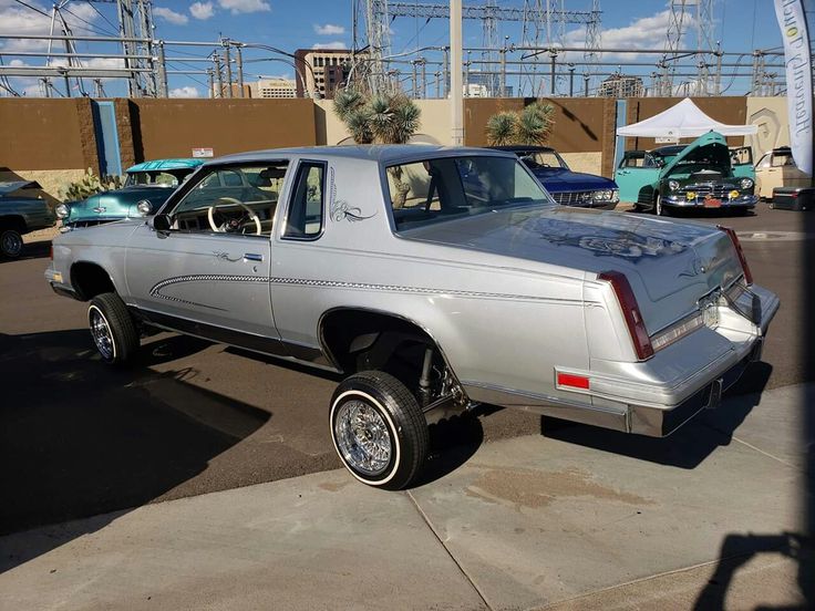 a silver car parked in a parking lot next to other cars