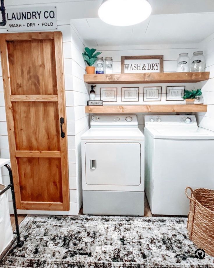 a washer and dryer sitting in a room next to a wooden door that says laundry co