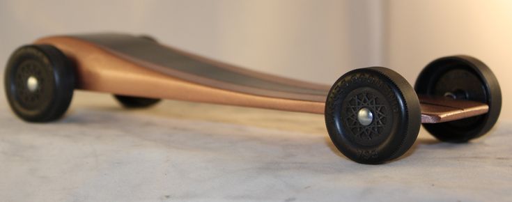 a wooden skateboard with black wheels on a white surface