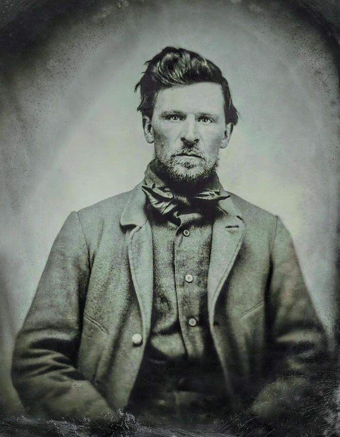 an old black and white photo of a man with a beard wearing a suit jacket