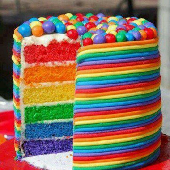 a rainbow cake with one slice cut out