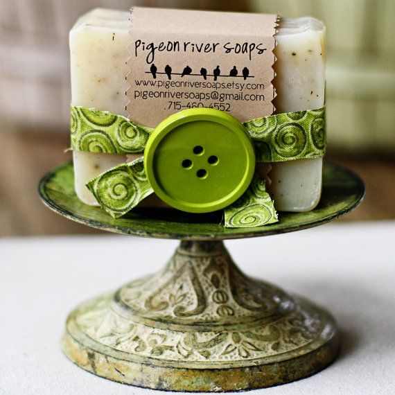 two soaps sitting on top of a green plate with a button attached to it