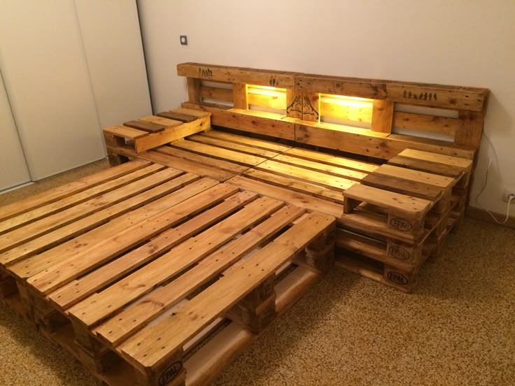 a bed made out of wooden pallets with two lights on each side and no headboard