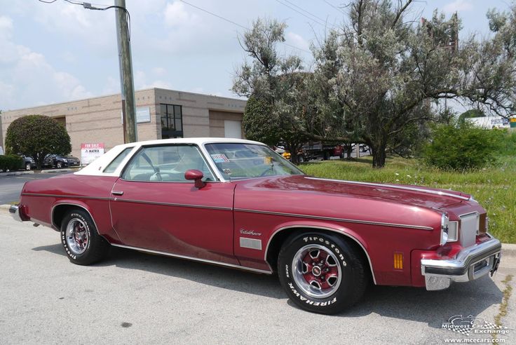 a red and white car parked in front of a building